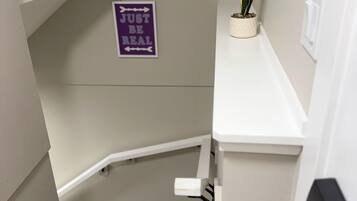 Eine Treppe mit einem Schild an der Wand, auf dem 'JUST BE REAL' steht.