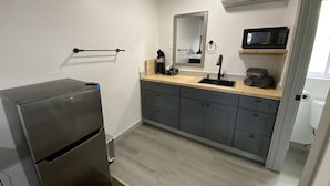 Kompakti keittokomero, jossa on sisäänrakennettu jääkaappi, mikroaaltouuni ja pesuallas.