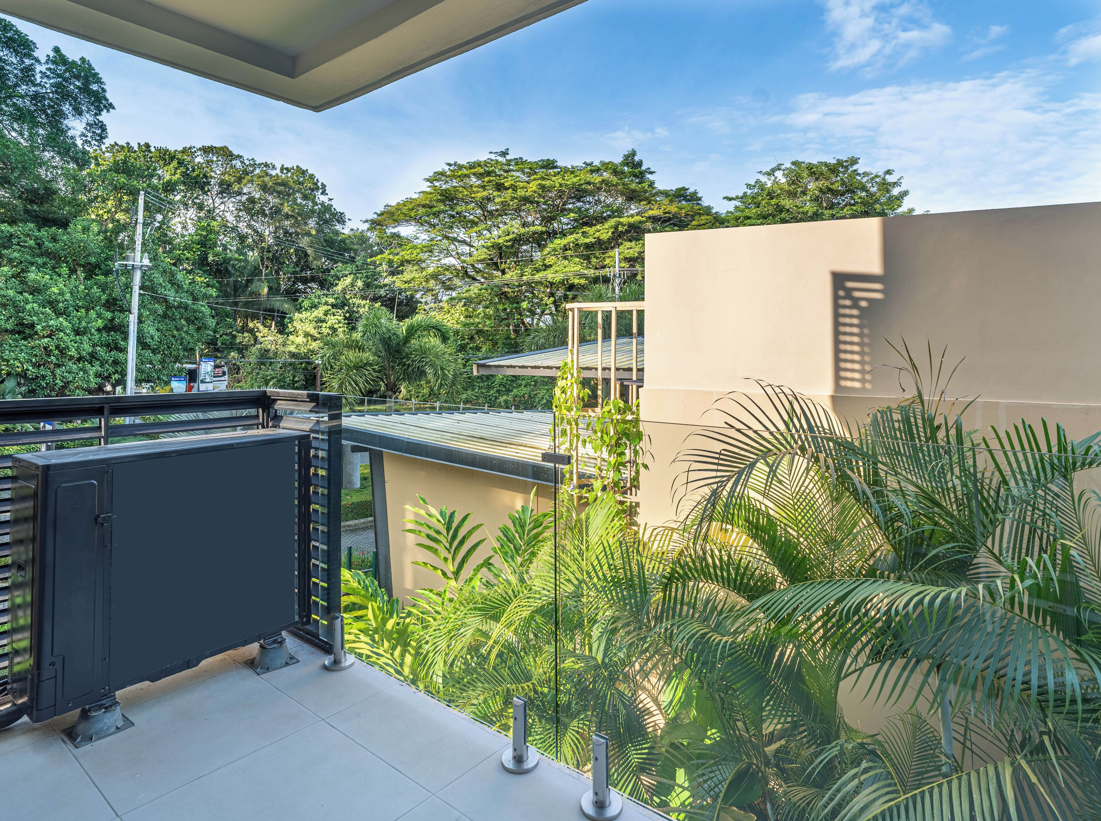 Terraço no telhado com vista para vegetação exuberante e um edifício moderno.