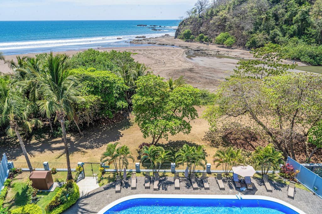Un espace piscine offrant une vue sur la plage et l’océan.