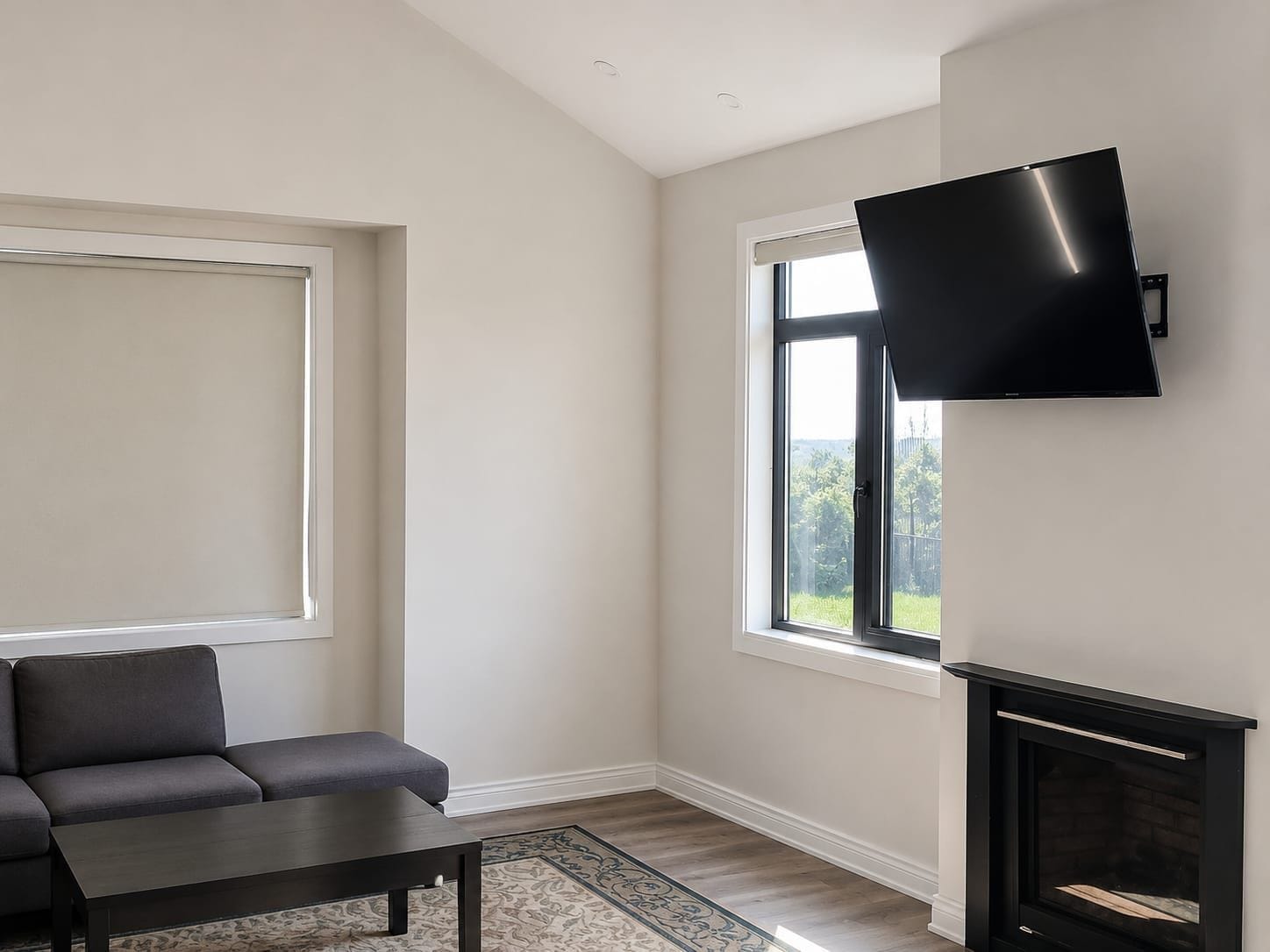 Ein modernes Wohnzimmer mit einer Couch, einem Flachbildfernseher an der Wand und einem Kamin.