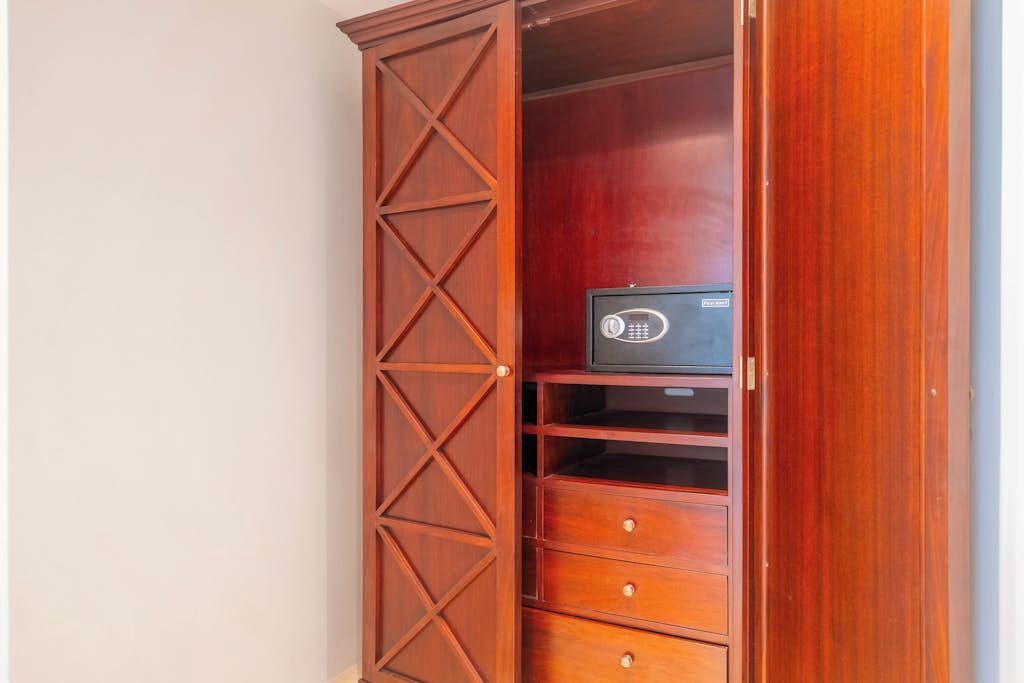 A wooden cabinet with drawers and a shelf, containing a black electronic device.