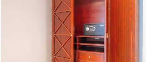 A wooden cabinet with drawers and a shelf, containing a black electronic device.