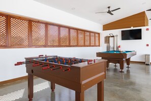 A room with a foosball table, a pool table, and a television mounted on the wall. - Viva Jaco Ocean View 3BD/2BT (07-02C) (Jacó)