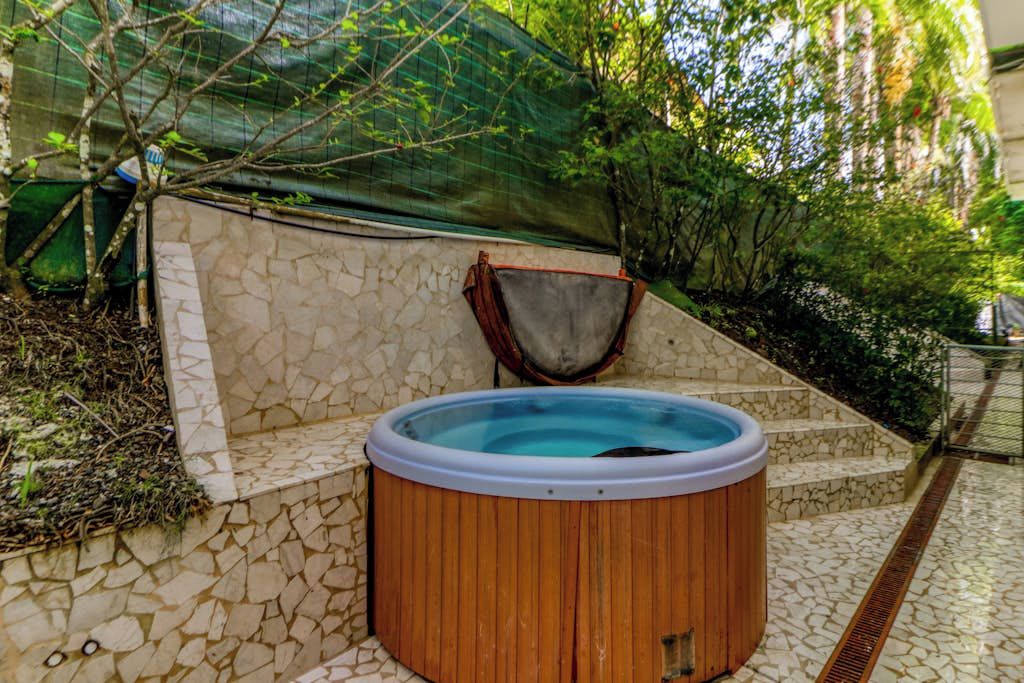 Uma banheira de hidromassagem com parede de pedra e deck de madeira.