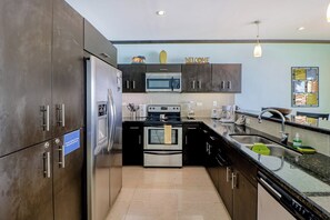 Een moderne keuken met roestvrijstalen apparatuur, een ingebouwde oven en een magnetron.