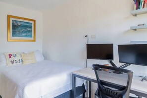 A hotel room with a bed, two monitors, a desk, and a chair. - Mistico Serenity Shores at Nautilus (Playa Hermosa)