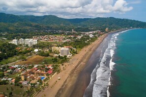 Eine Küstenstadt mit Strand, Wohnhäusern und einer bergigen Kulisse.