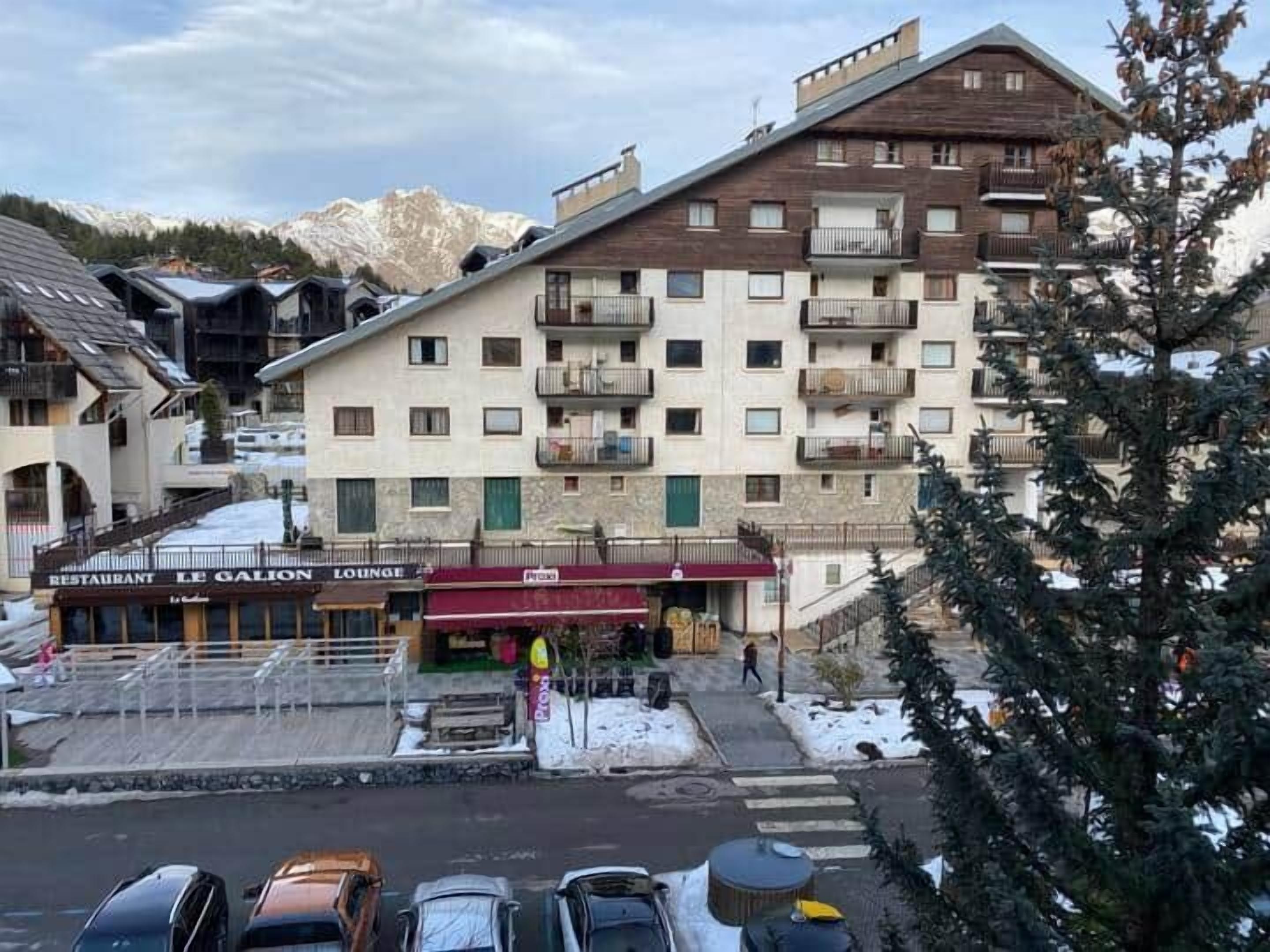 Hotel com vários andares, varandas, restaurante e área de estar.