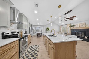 Una cocina moderna con una isla central, horno integrado y electrodomésticos de acero inoxidable.