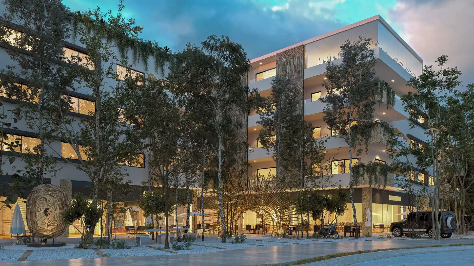 Un hotel de varios pisos con asientos al aire libre y árboles.