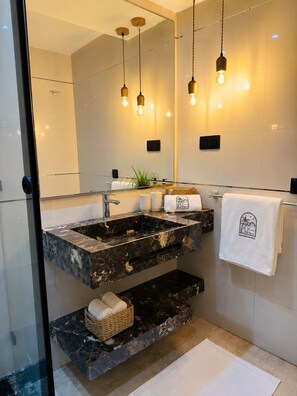 A modern bathroom with a large mirror, two sinks, and a towel rack.