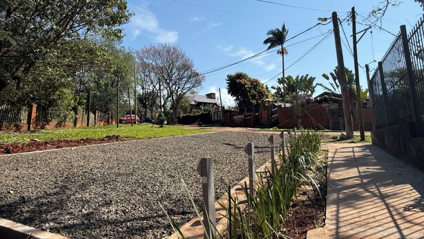 A residential street with a paved road, a sidewalk, and a fence. - Minimalist apartment in the jungle (Puerto Iguazú)
