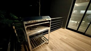 A kitchen area with a built-in oven and a stainless steel cart. - Minimalist apartment in the jungle (Puerto Iguazú)