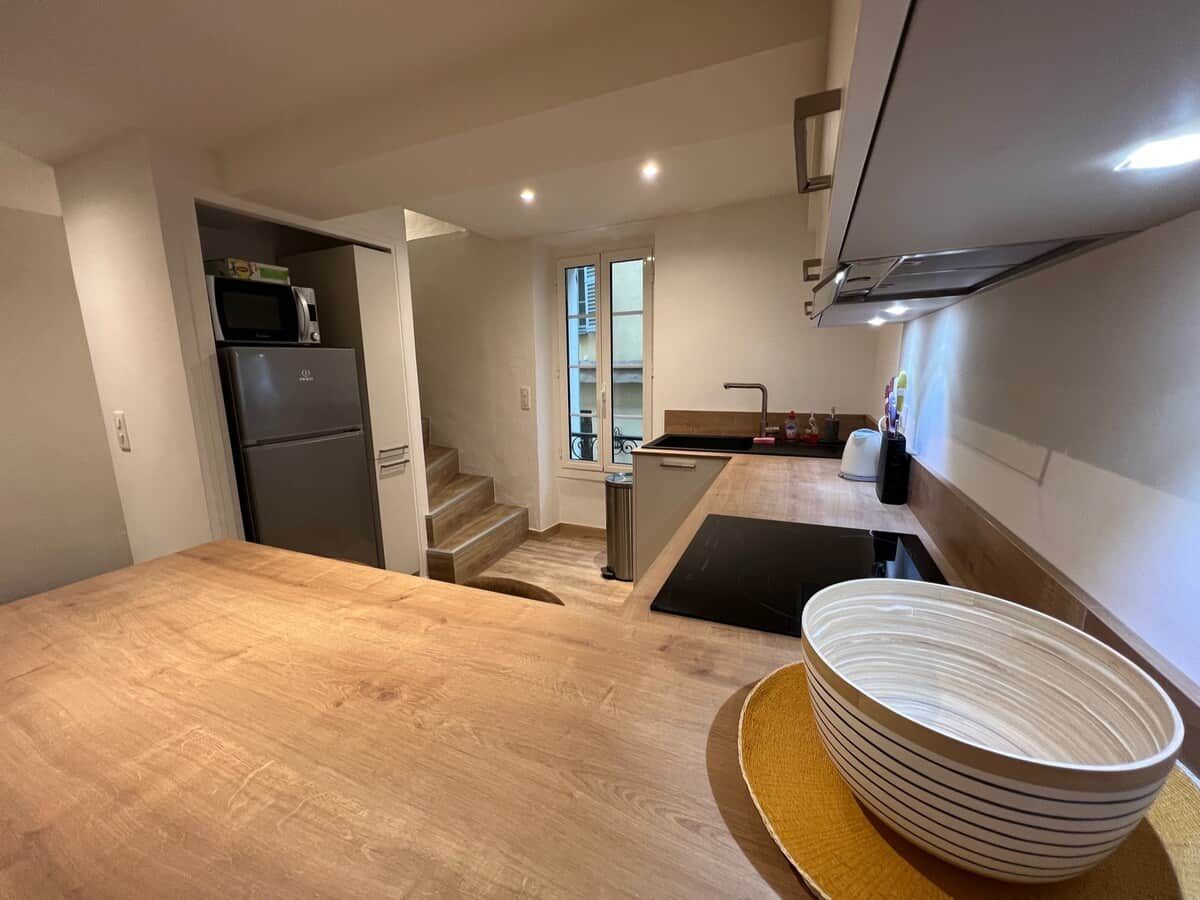A compact kitchen with a wooden countertop, a built-in microwave, and a sink.