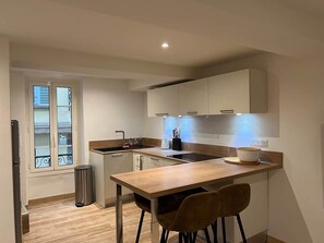 A modern kitchen with a wooden countertop, a sink, and a window with blinds. - Valbonne Village - Rue Giraud (Valbonne)