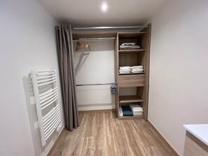 A walk-in closet with wooden shelving, a radiator, and a hanging rack. - Valbonne Village - Rue Giraud (Valbonne)