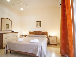 A hotel room with a bed, bedside tables, a dresser, a mirror, and a window with curtains. - Sea-view Etna Residence (Trecastagni)