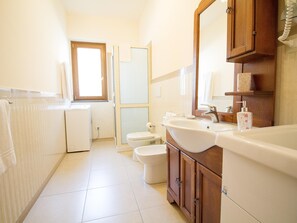 A bathroom with a toilet, sink, and shower area. - Sea-view Etna Residence (Trecastagni)