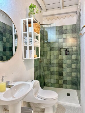 A bathroom with a toilet, sink, and shower area. - by Calamari.Homes - Casa Aura Victoria - Visitors permitted (Cartagena de Indias)