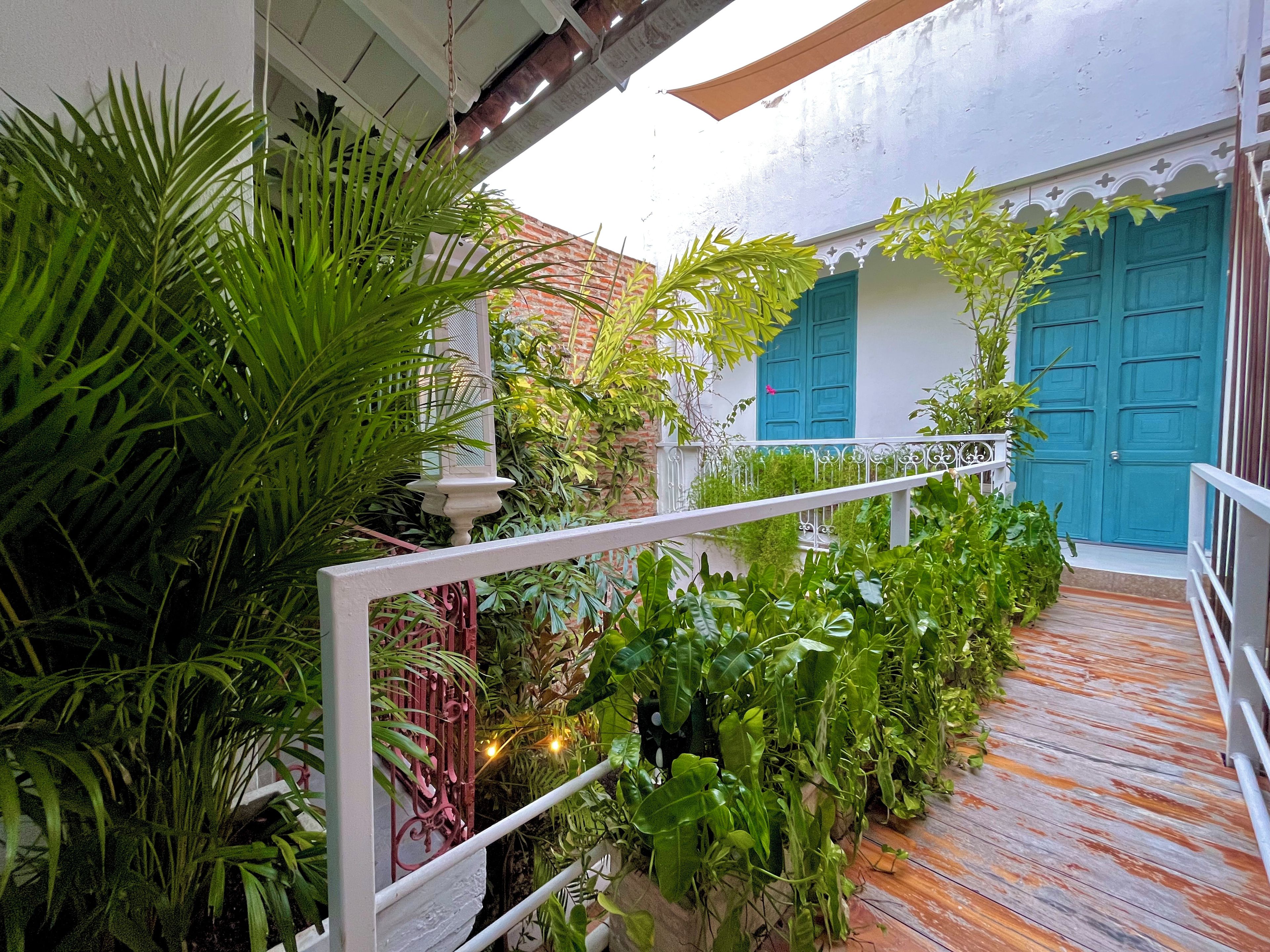 A wooden pathway leading to a building with a white facade and blue doors.
