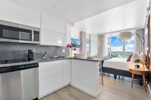 A modern kitchen with a built-in microwave, coffee machine, and dishwasher. - Stylish Studio – Coconut Grove Retreat (Miami)