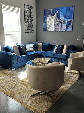 A living room with a sectional sofa, a round coffee table, and a floor lamp. - "Beautiful Luxury Loft in the Heart of Downtown" (Memphis)