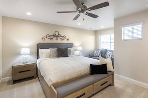 A bedroom with a bed, bedside tables, a ceiling fan, and a window with blinds. - Golden Gem with Views - Pool, PickleBall, 86" Smart TVs (Washington)