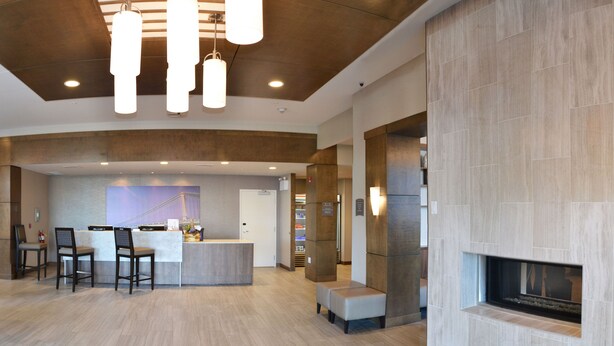 Eine moderne Lobby mit Empfangsschalter, Sitzgelegenheiten und Kamin.