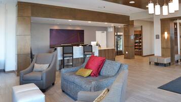 A lobby with seating, a reception desk, and a large wall mural.