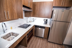 Una cocina moderna con electrodomésticos de acero inoxidable, armarios de madera y lavavajillas.