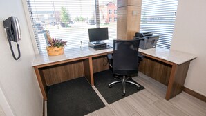 Un espacio de oficina moderno con escritorio, computadora, silla e impresora.