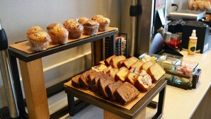Mostrador de panadería con muffins y panes.