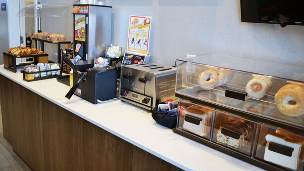 Una barra de desayuno con diferentes opciones de alimentos y una máquina de café.