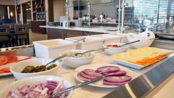 A buffet with various food items including sliced vegetables and a salad.