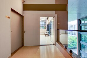 A hallway with a door marked 644, leading to a waiting area with chairs and a view of buildings outside.