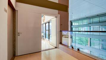 Un pasillo con un vidrio que da a una habitación con vistas a edificios.