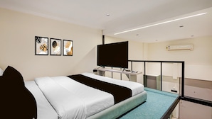 A modern hotel room with a bed, a desk, a flat-screen TV, and a window. - Suite Room Hotel Nano Pod (Surat)