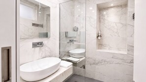 A modern bathroom with a large marble sink, a glass-enclosed shower, and a built-in mirror. - VIVA Janelas Verdes Residence (Lisboa)