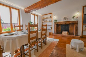 A dining area with a table set for four, wooden chairs, a fireplace, and a bookshelf. - A l'Aube des Lacs - LUSIGNY SUR BARSE (LUSIGNY SUR BARSE)