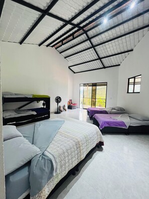A room with bunk beds, a fan, and a window with a view.