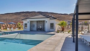 A swimming pool area with a covered structure, lounge chairs, and a mountainous backdrop. - Heated Pool & Pickleball - Beautiful 3BR Home Near Zion (Washington)