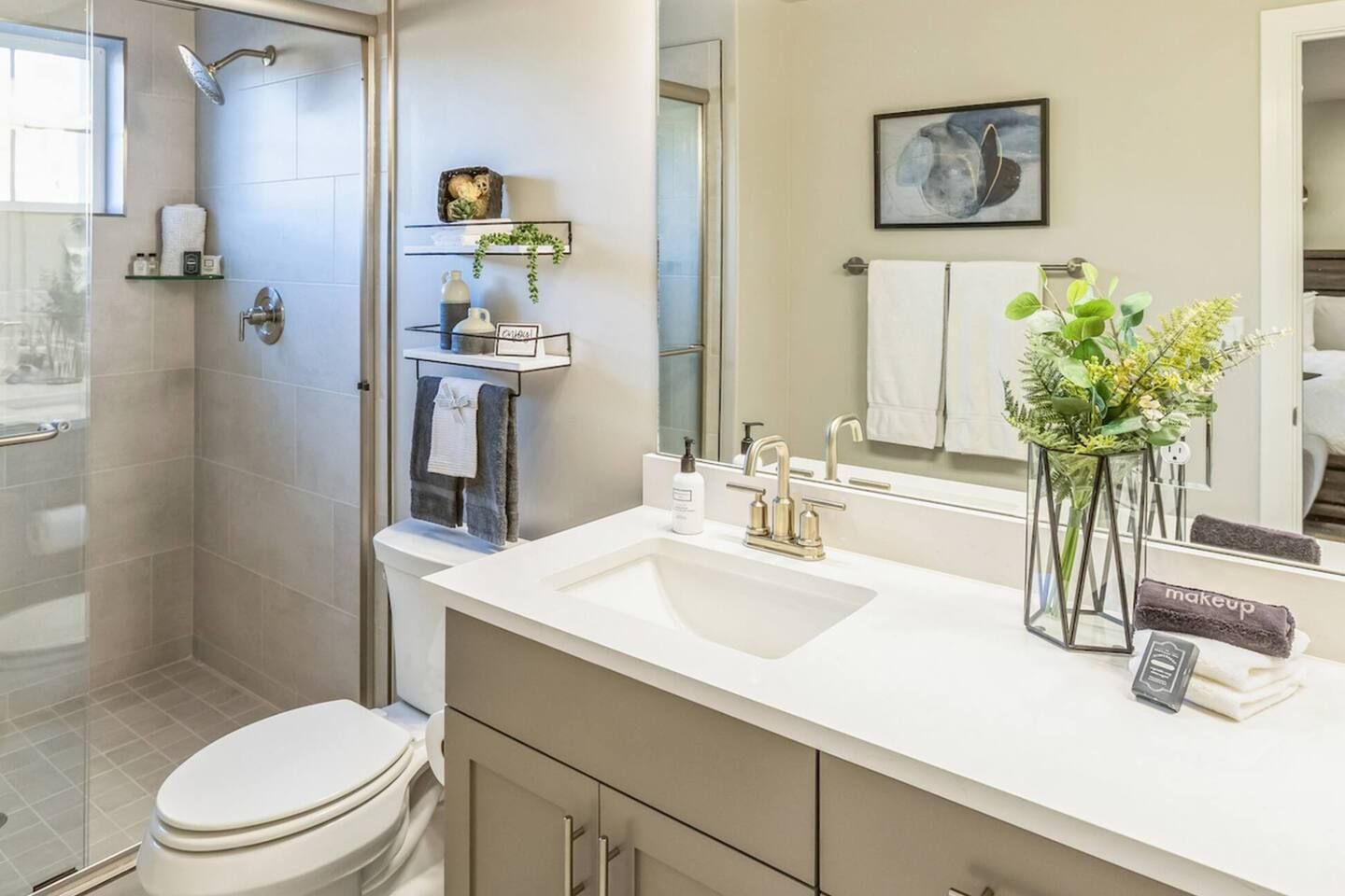 A modern bathroom with a shower, toilet, vanity, and a large mirror.
