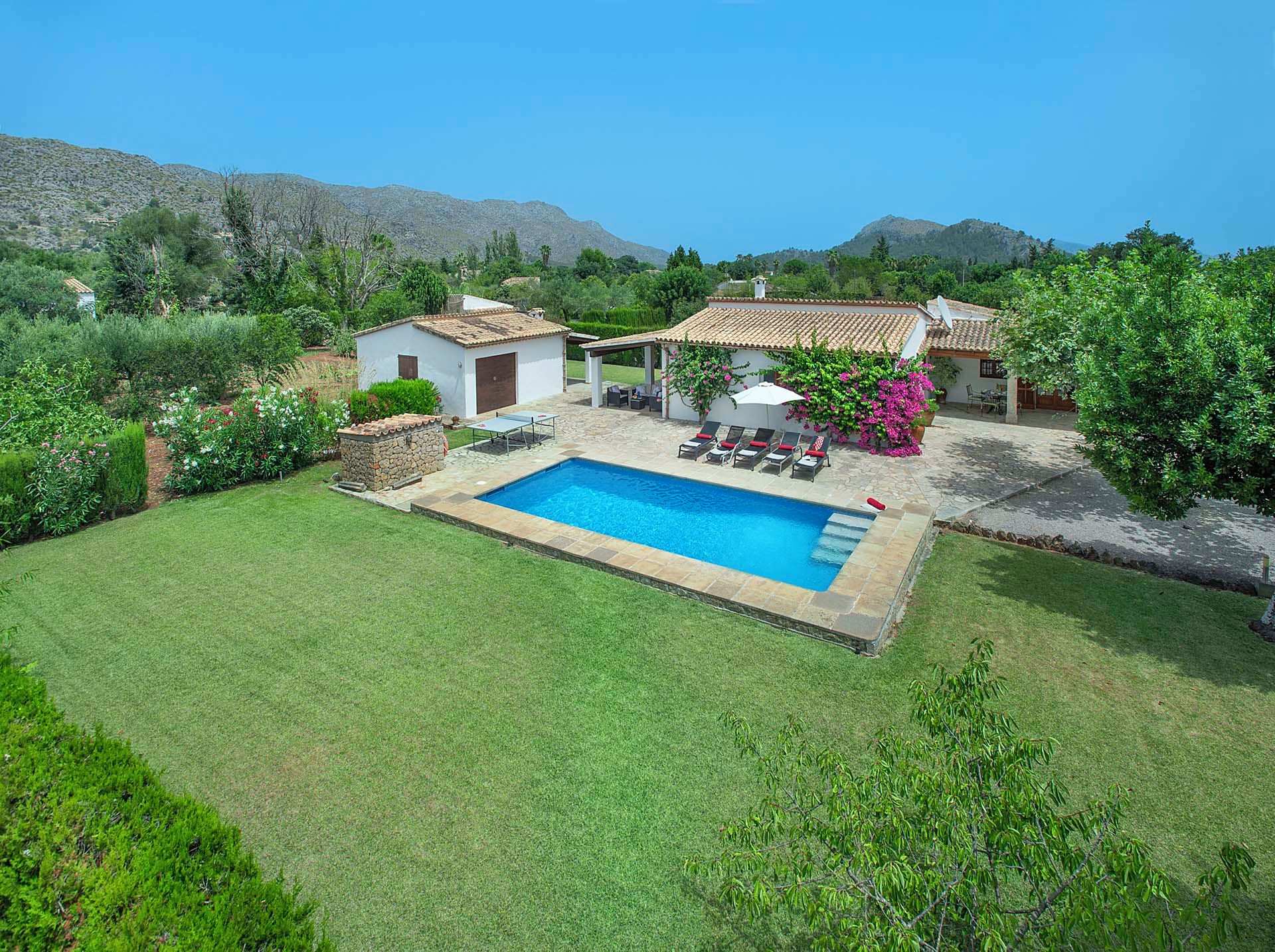 A residential property with a swimming pool, outdoor seating, and a garden.