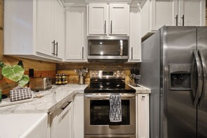 Una cocina moderna con electrodomésticos de acero inoxidable, incluyendo un microondas, horno y refrigerador.