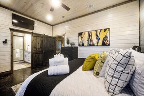 Ein Hotelzimmer mit Bett, einem Gemälde und Blick ins Freie.