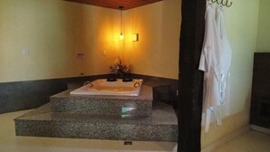 Ein Badezimmer mit einer Badewanne, einem Handtuchhalter und einer Wandleuchte.