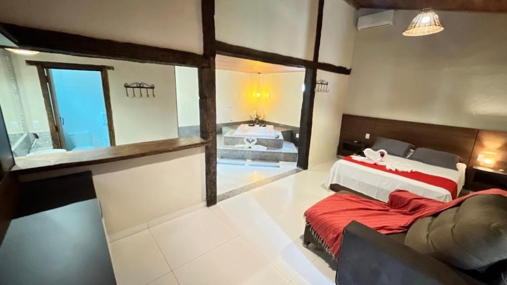 Una habitación de hotel con cama, sofá, una mesita y vistas a un balcón.