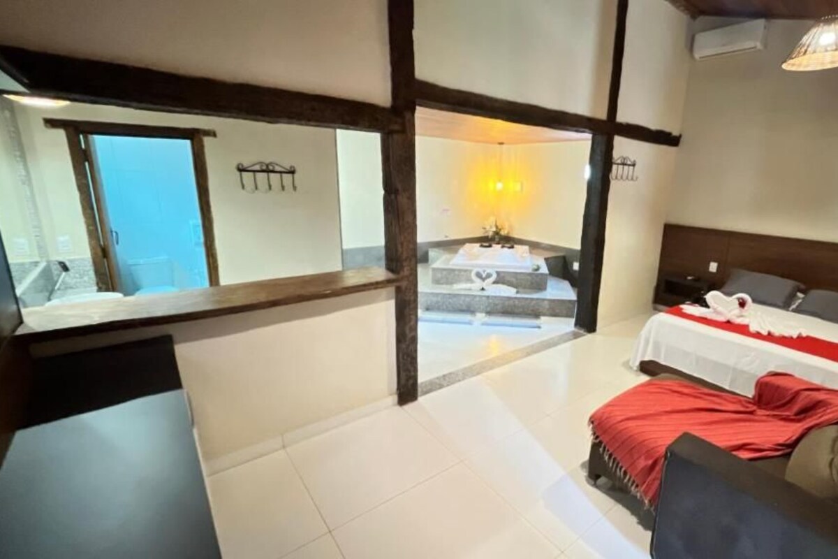 A hotel room with a bed, a sofa, a small table, and a view of a balcony.