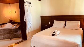 Een hotelkamer met een bed, een badkamer met een bad en een houten plafond.